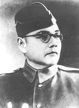 Black-and-white portrait of Netaji Subhas Chandra Bose wearing round spectacles and a military-style cap